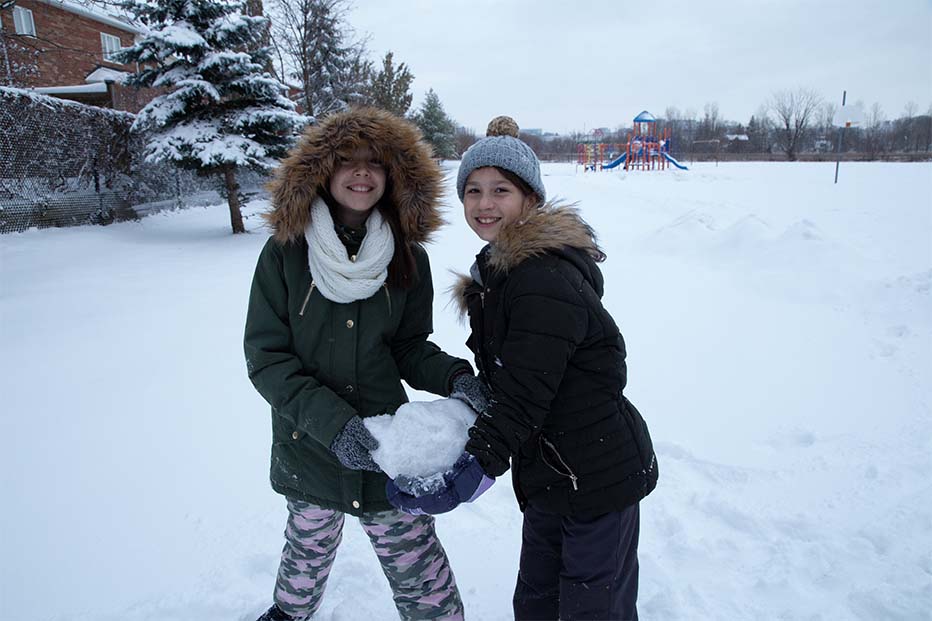 two girls holding a huge snowball